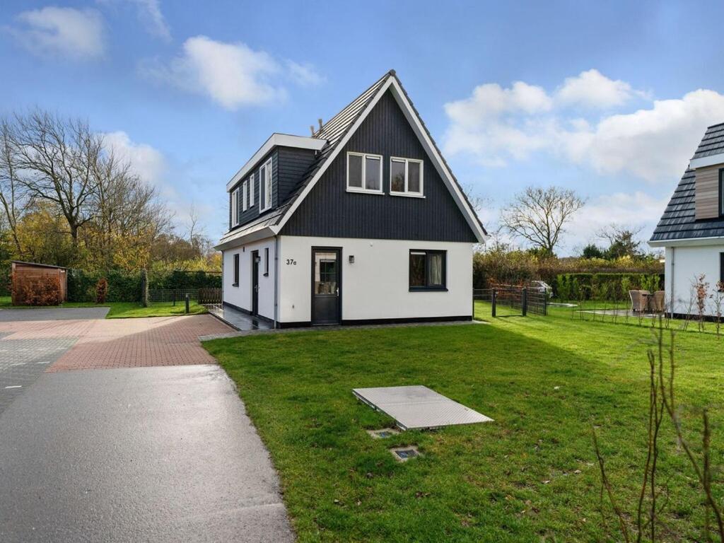 a large white house with a black roof at Wonderful Holiday Home in De Koog Texel with Terrace in Westermient