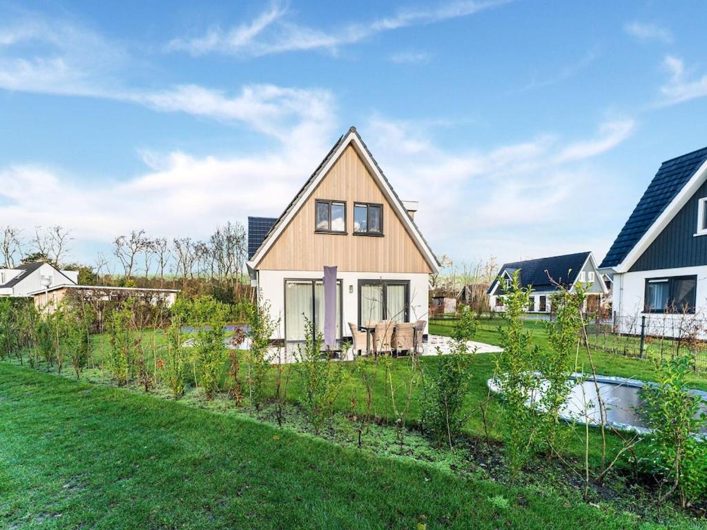 een huis met een tuin in de tuin bij Alluring Holiday Home in De Koog Texel with Infrared Sauna in Westermient