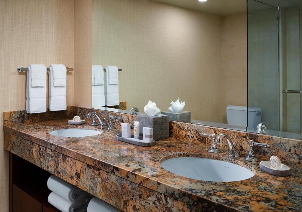 a bathroom with two sinks and a large mirror at Little America Hotel Salt Lake City in Salt Lake City