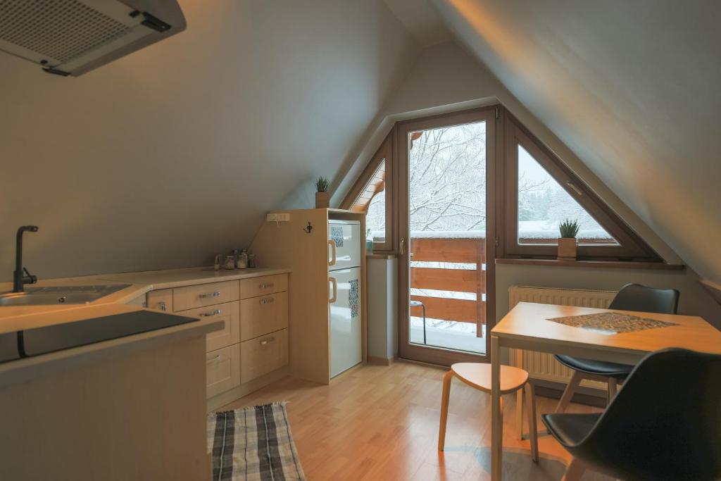 a kitchen with a table and a refrigerator and a window at Golden Apartments Zakopane&B13 in Zakopane