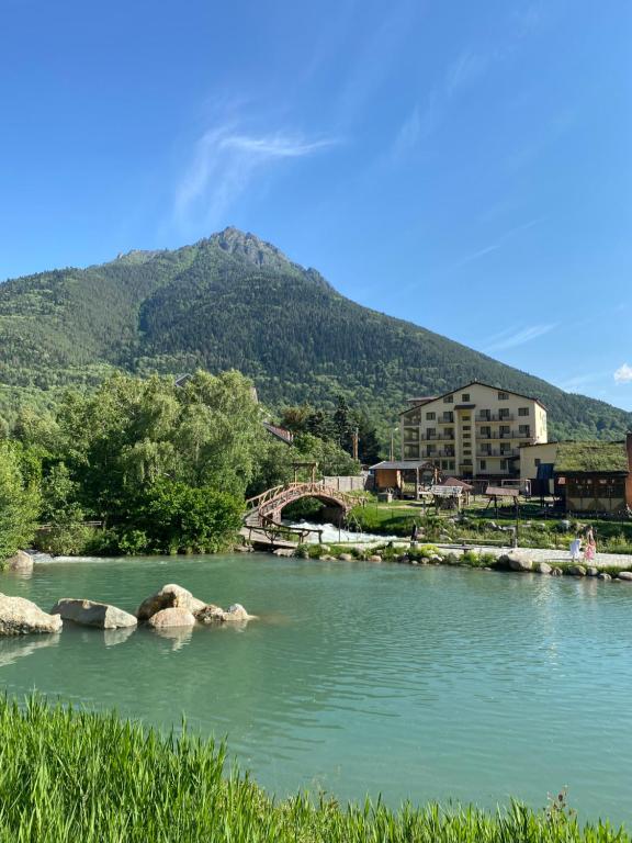 a river with a bridge in front of a mountain at Yetihouse in Teberda