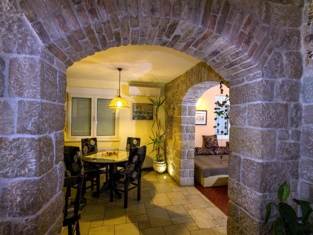 Zimmer mit einer Steinmauer, einem Tisch und Stühlen in der Unterkunft Apartment Bilic in Zadar