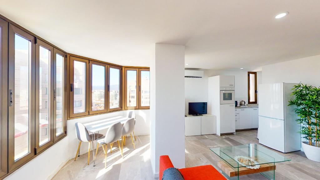 een woonkamer met witte muren en grote ramen bij Las Palmeras - Best Location Cozy Apartment in Fuengirola