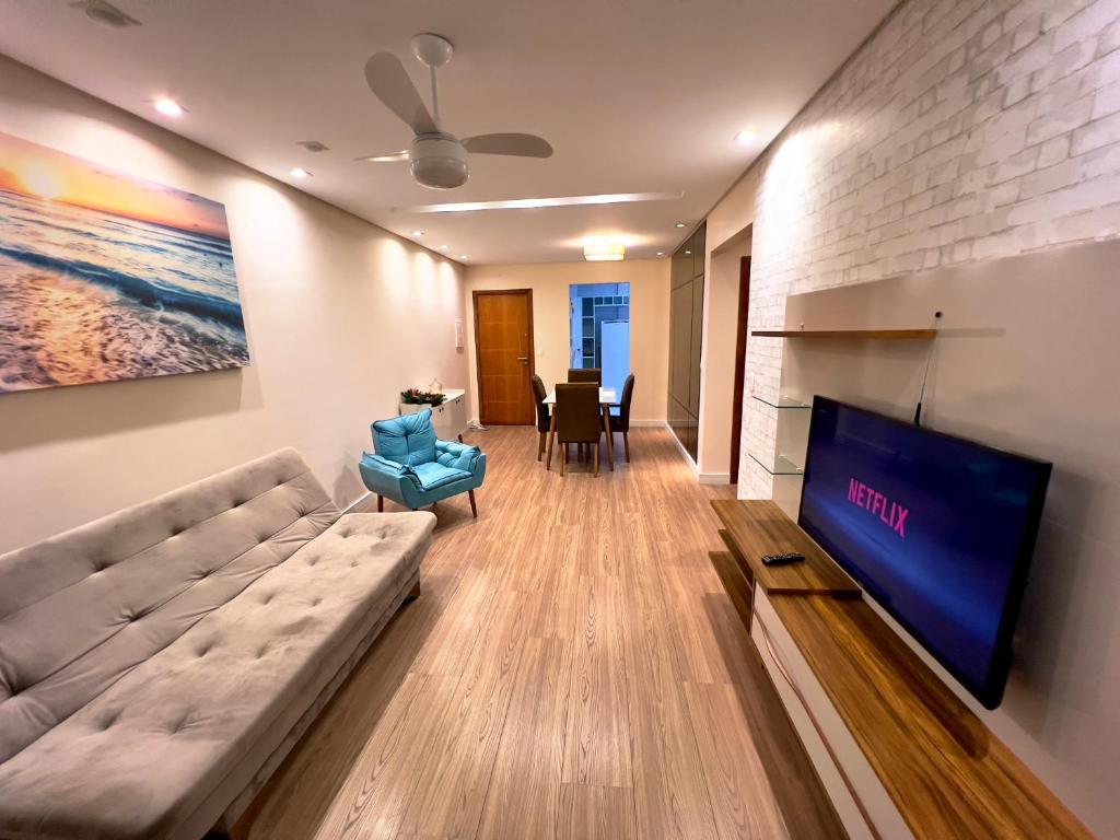 a living room with a couch and a tv at Apartamento 82 - Guilhermina in Praia Grande