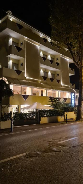 a large building with lights on it at night at Hotel Beppe in Rimini