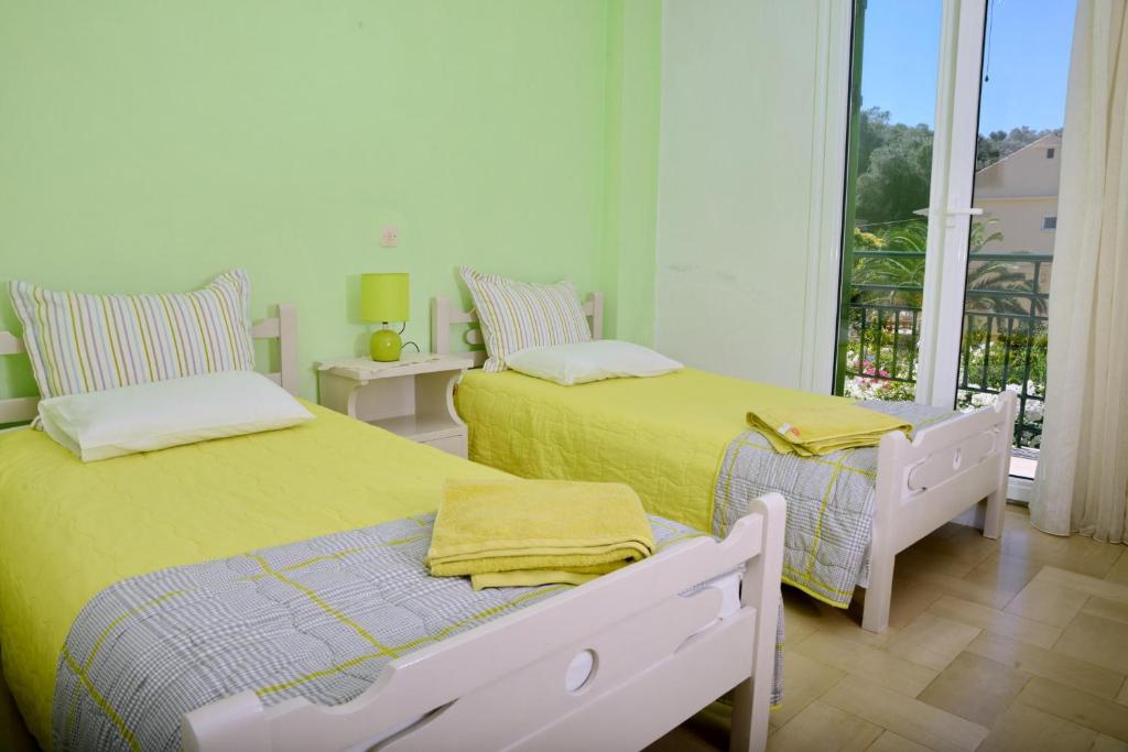 sypialnia z 2 łóżkami i balkonem z widokiem w obiekcie Eirini - LOGGOS APARTMENTS w mieście Longós