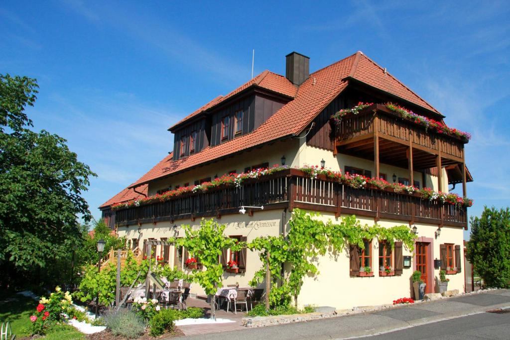 Un edificio con flores en el costado. en Hotel & Gasthof zum Rödelseer Schwan, en Rödelsee