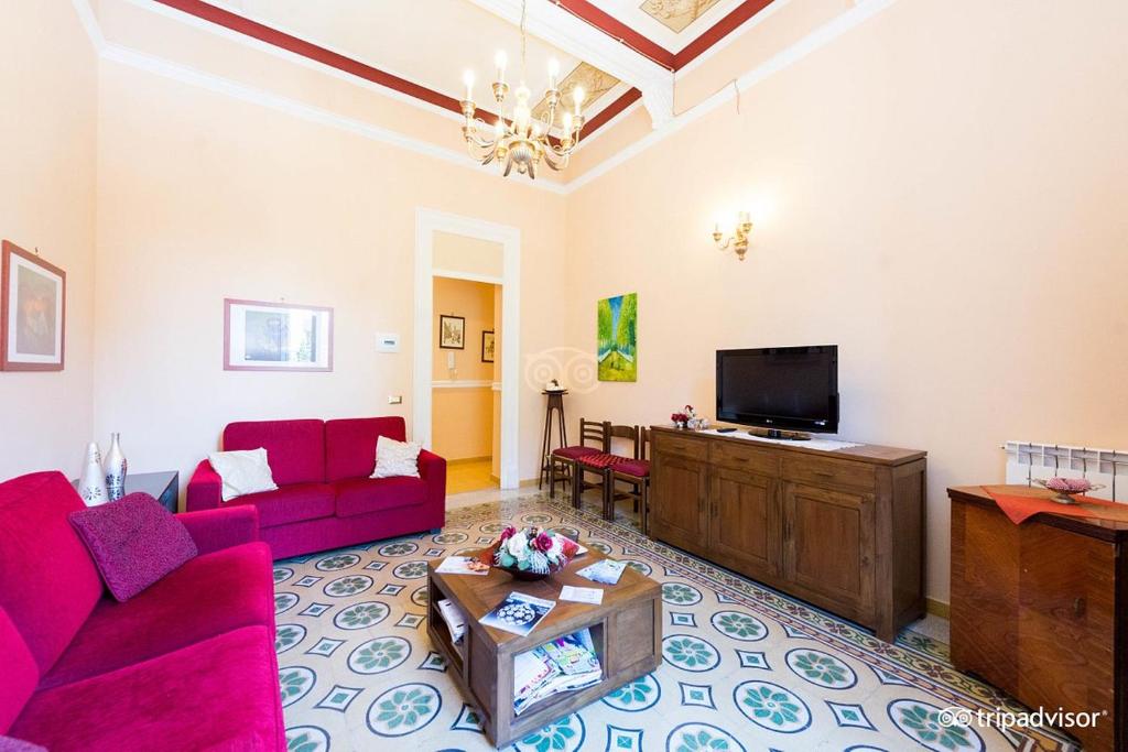 een woonkamer met een rode bank en een tv bij A Casa di Anna - Apartment in Palermo