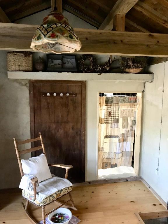 a chair in a room with a window and a lamp at Travelers House おーさんてぃん青空舎 in Taketomi