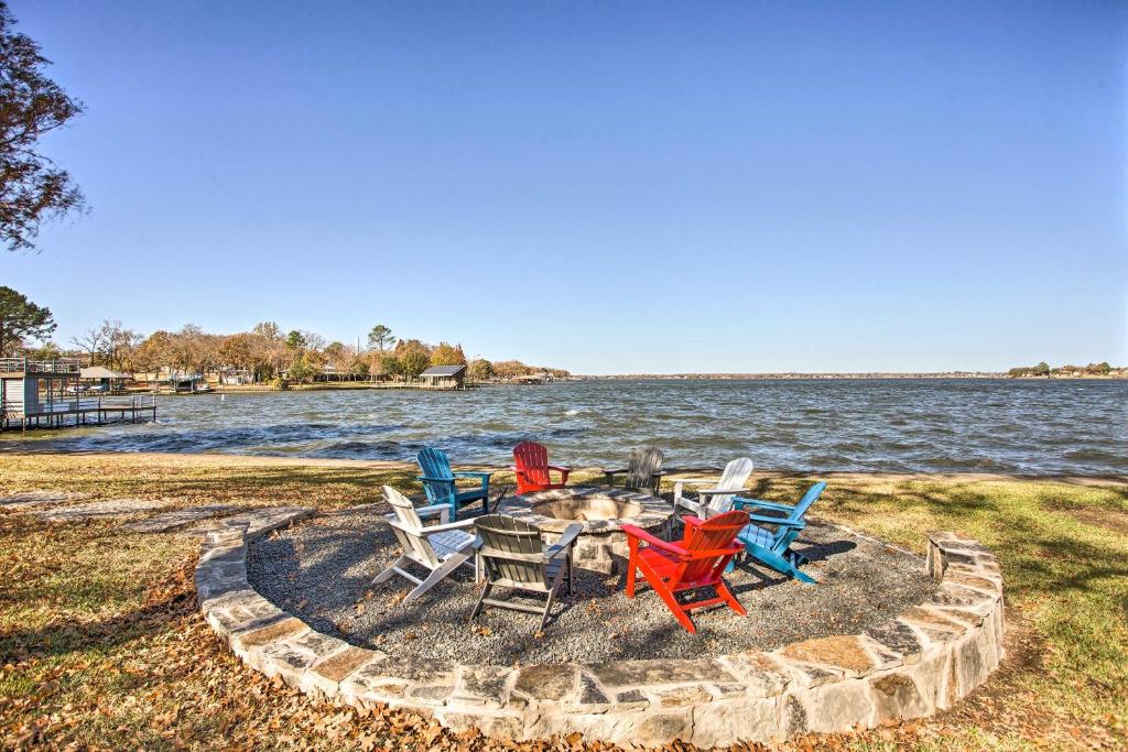 a group of chairs sitting around a fire pit by the water at Upscale Lakefront Texas Home Private Dock and Decks in Malakoff