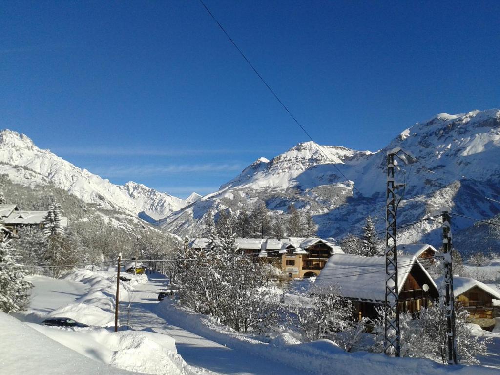 eine Skihütte im Schnee mit Bergen im Hintergrund in der Unterkunft Hôtel Aigliere in Puy-Saint-Vincent