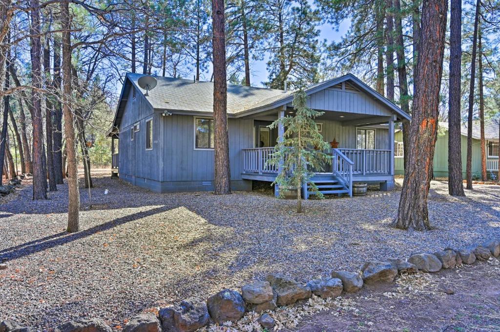 a small blue house in the middle of the woods at Near Hiking and Golfing Pinetop Home with Deck! in Indian Pine