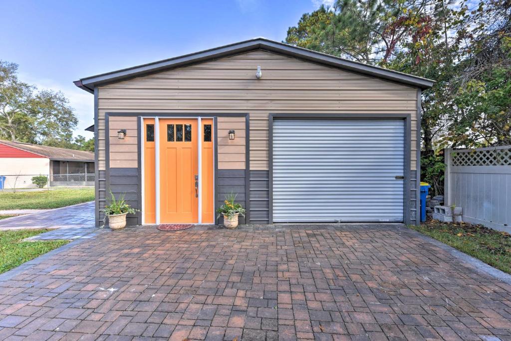 eine Garage mit einer orangefarbenen Tür auf einer steinernen Einfahrt in der Unterkunft Cozy Jacksonville Studio - 10 Miles to Downtown! in Jacksonville