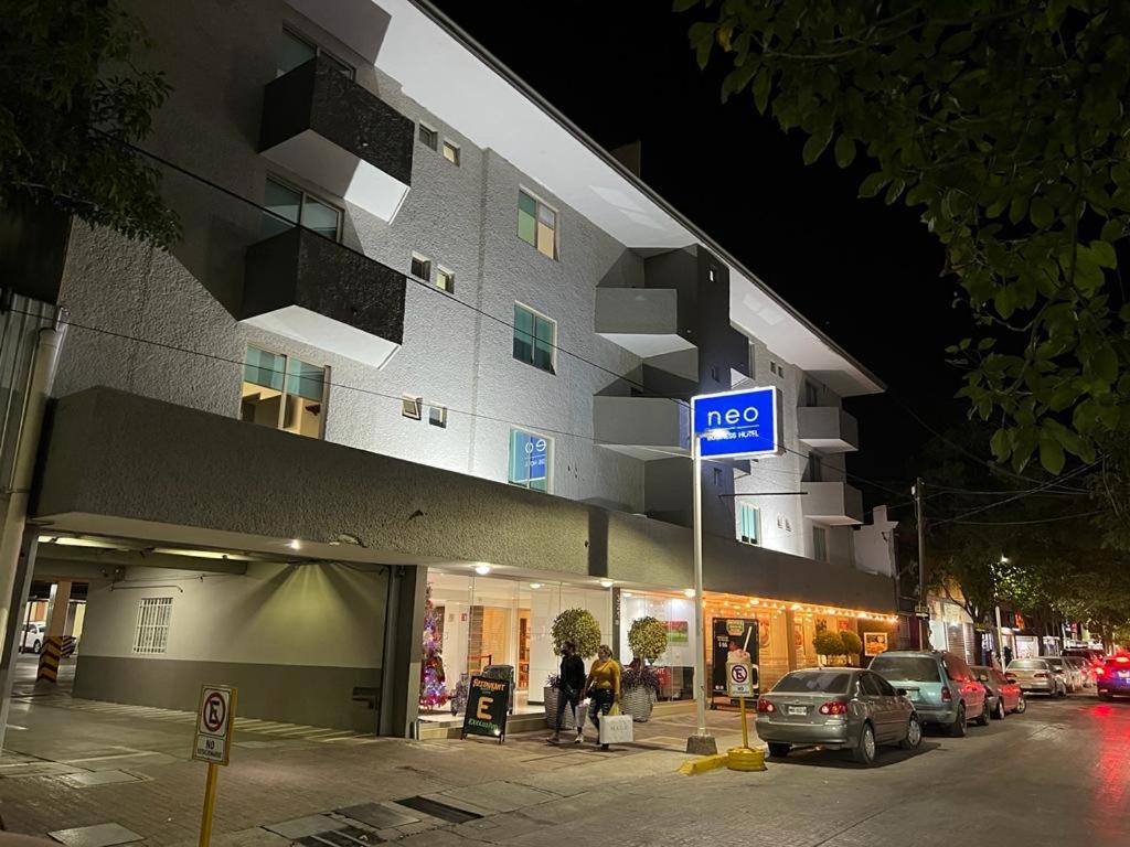 un letrero de la calle frente a un edificio por la noche en Neo Business Hotel en Culiacán