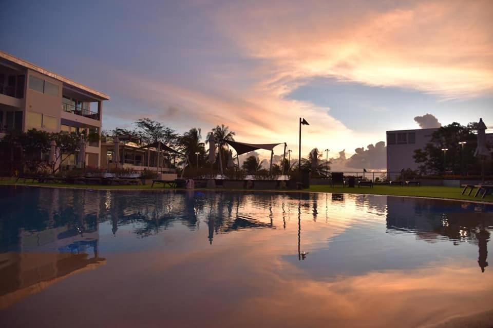 una grande piscina d'acqua di fronte a un edificio di KARON BUTTERFLY KATA HILL CONDO By THE SEA a Ban Karon