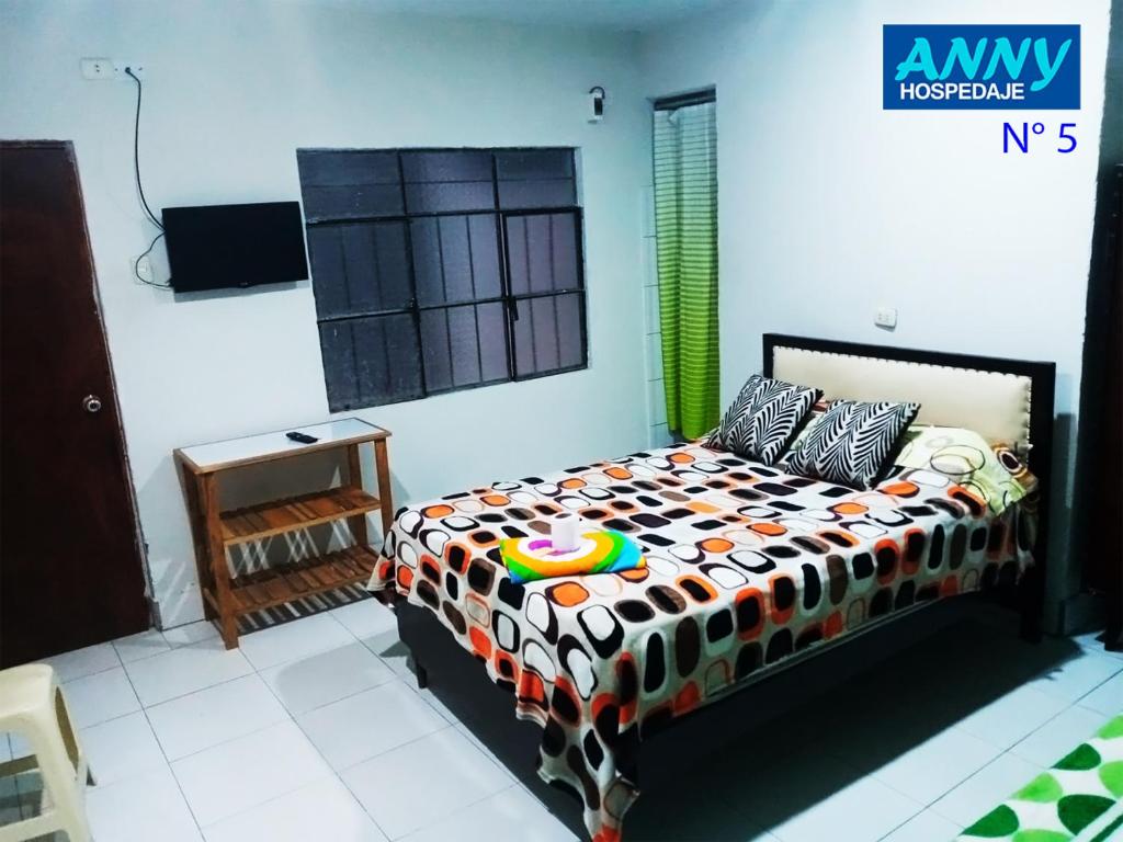 a bedroom with a bed with a colorful comforter at Hospedaje Anny in Larán