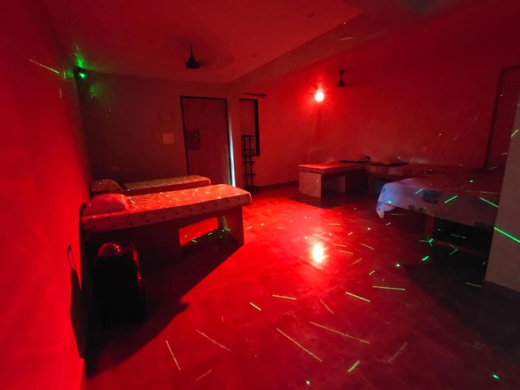an empty room with red lights in a dark room at Godwill Kimo Guest house Seraulim in Madgaon