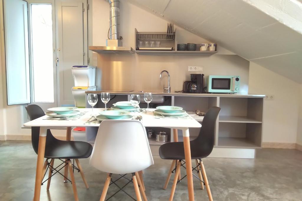 a kitchen with a table with chairs and a microwave at Apartamentos Turísticos As Burgas 6 by Bossh Hotels in Ourense
