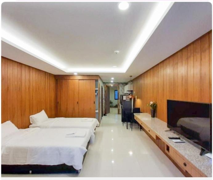 Private wooden style studio room in city area في شيانغ ماي: غرفة كبيرة بسريرين ومكتب