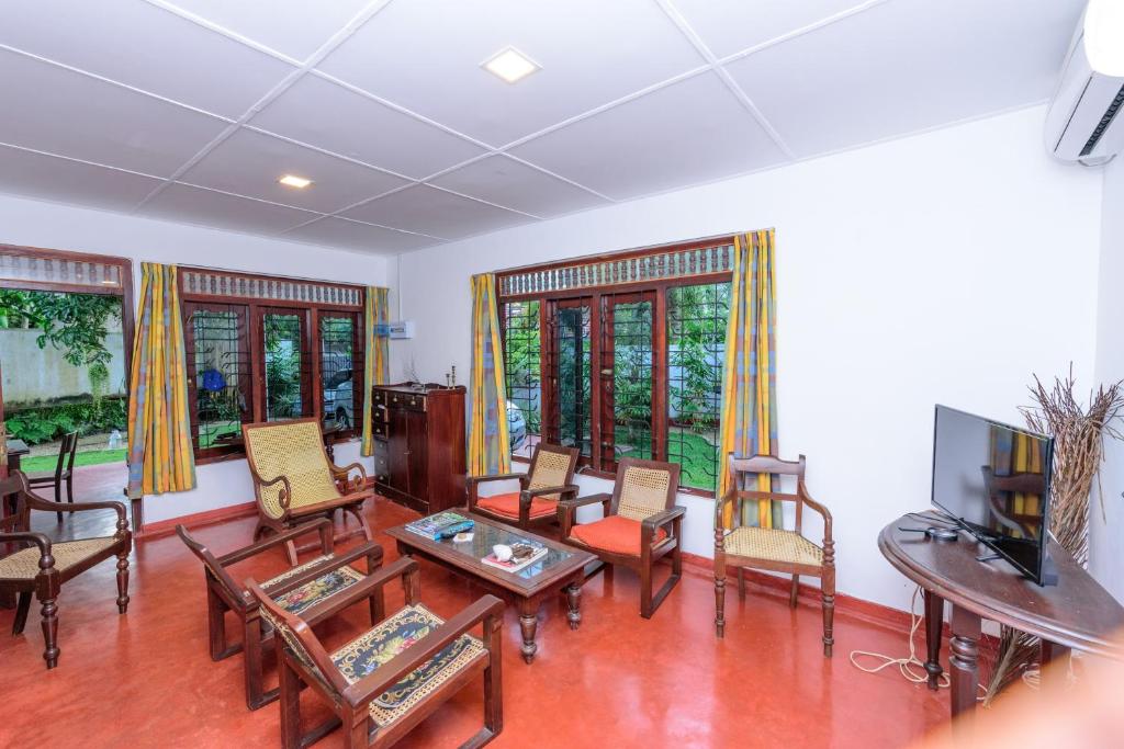 un soggiorno arredato con TV a schermo piatto di Villa Guru Hikkaduwa a Hikkaduwa