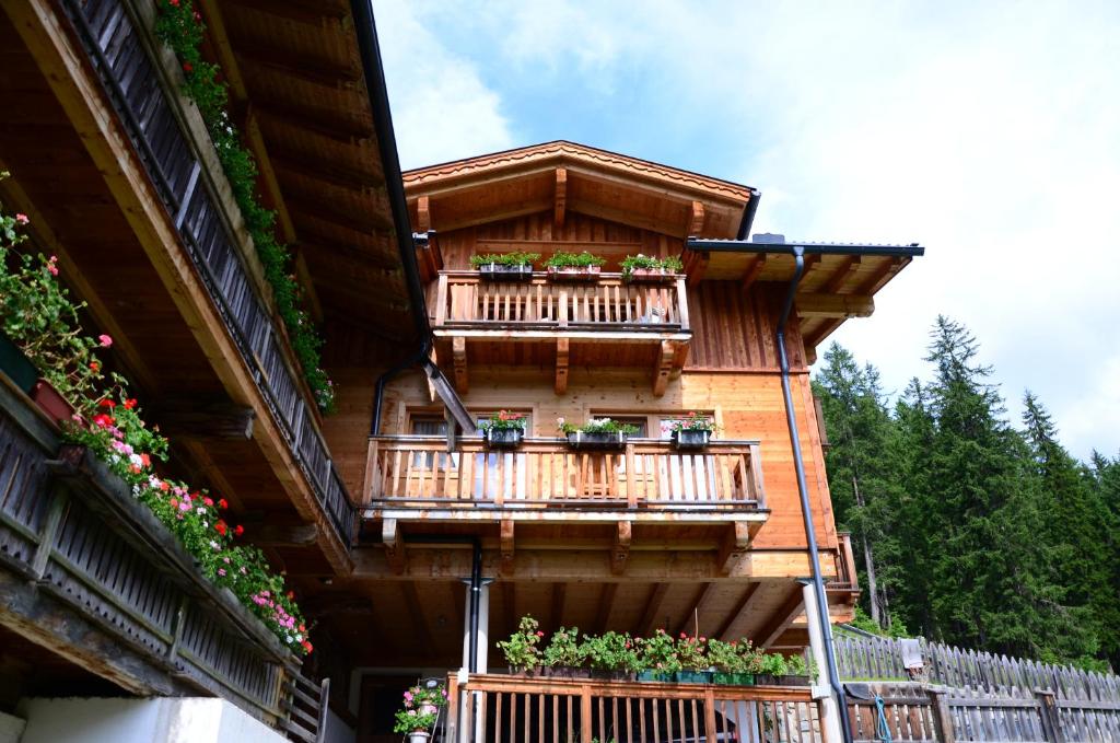 a building with balconies and flowers on it at Ferienhaus Schöneggerhof in Innervillgraten