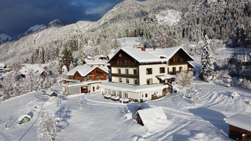 ein schneebedecktes Haus vor einem Berg in der Unterkunft Naturgut Gailtal in Sankt Stefan an der Gail