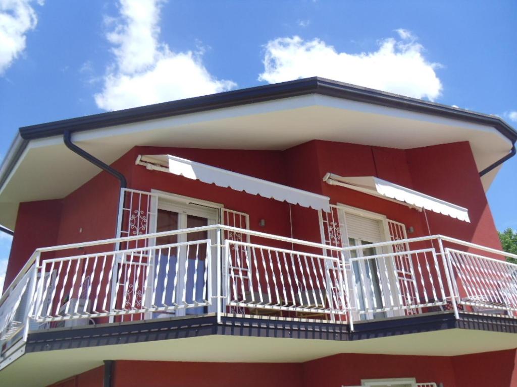 - un bâtiment rouge avec des balcons blancs dans l'établissement Appartamento Villa Tony, à Lazise