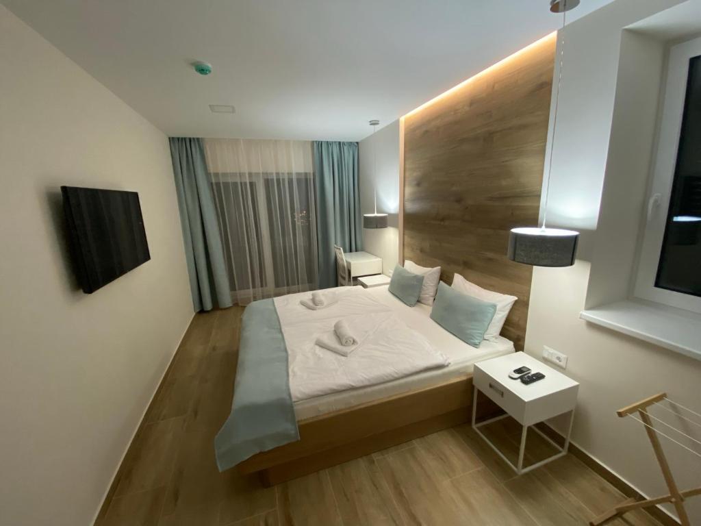 Dormitorio pequeño con cama y mesa en MAGNOLIA Room & Spa - ADULTS ONLY, en Csopak