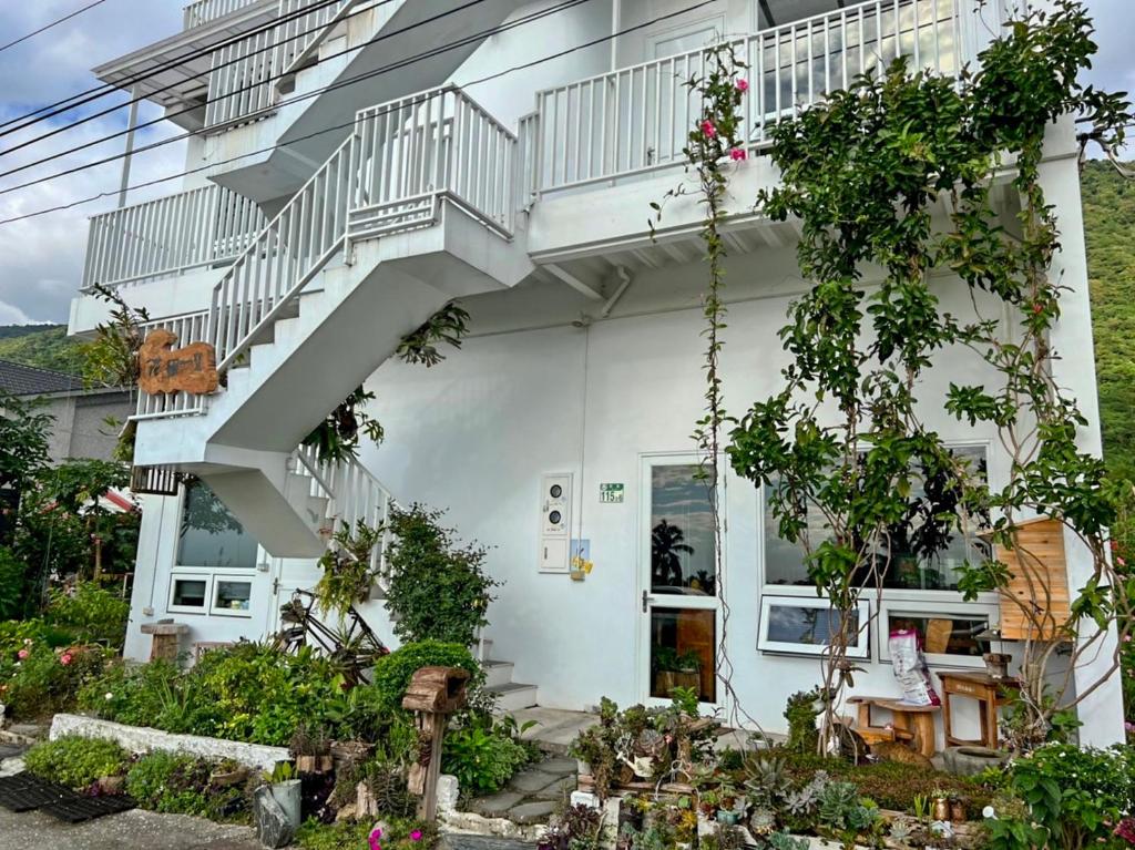 a white house with a staircase and some plants at Huatian Yilu in Xiulin