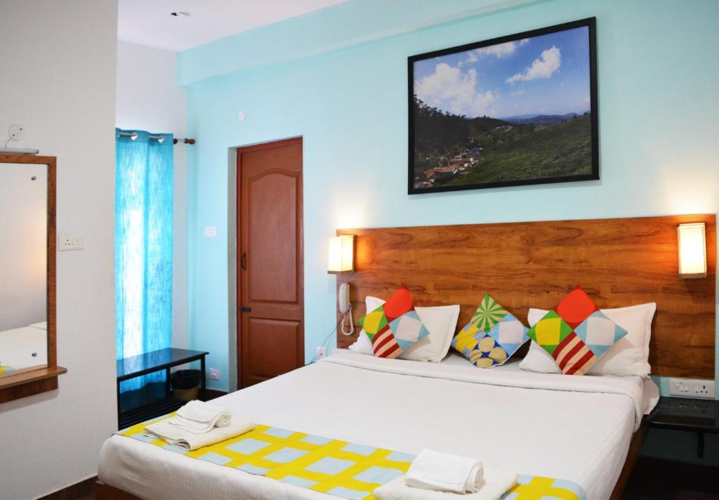 ein Hotelzimmer mit einem Bett und einem Spiegel in der Unterkunft EDEN Paradisee in Udagamandalam