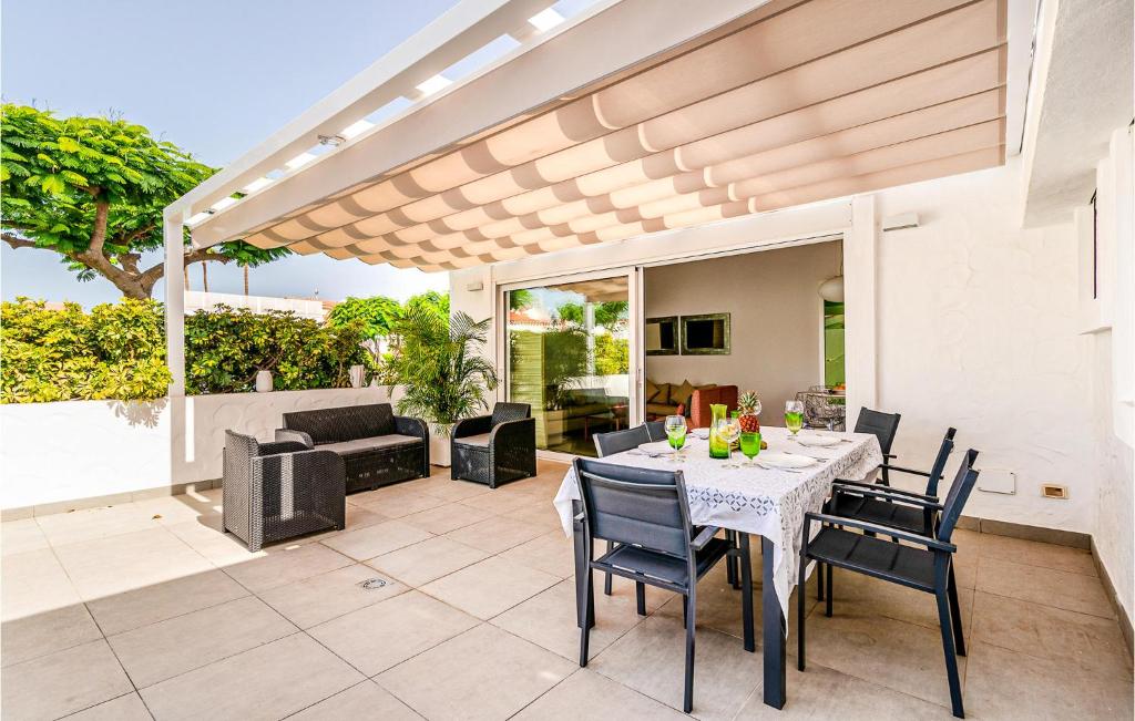 a patio with a table and chairs and a couch at Gorgeous Home In Gran Canaria With Outdoor Swimming Pool in Pasito Blanco