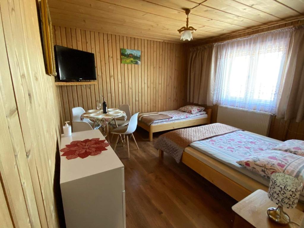 ブコビナ・タトシャンスカにある,, U Nikoli"のベッドルーム1室(ベッド2台、テーブル、テレビ付)
