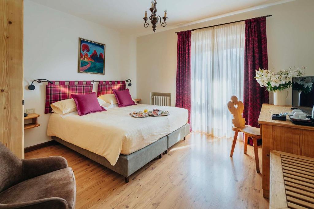 Кровать или кровати в номере Hotel Panda Cortina- ricarica auto elettriche