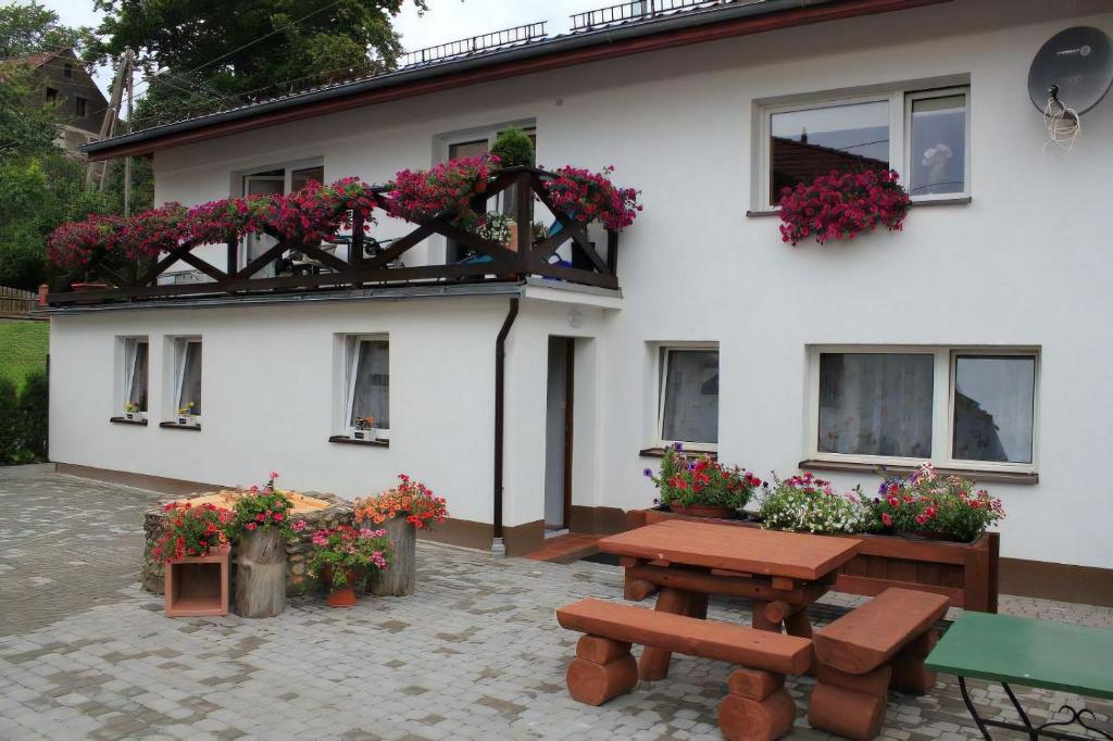 Jeżów Sudecki的住宿－Cztery Pory Roku，白色的房子,配有野餐桌和鲜花