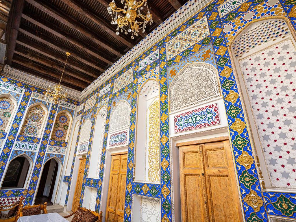 Habitación con azulejos azules y blancos en la pared en Rayyan Hotel Bukhara, en Bukhara