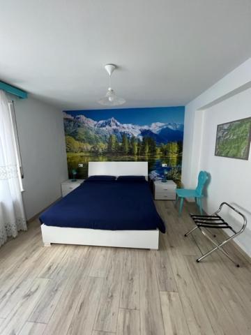 a bedroom with a bed and a painting on the wall at SUITE DOLOMITI Appartamento in Falcade