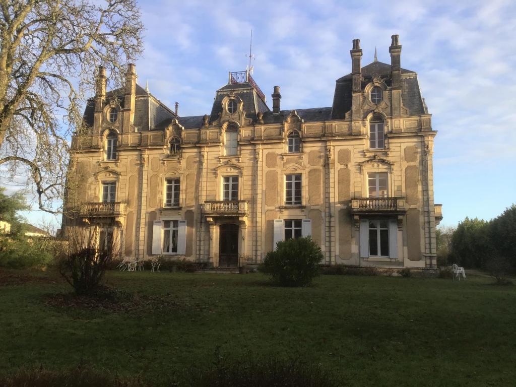 una vieja mansión con un campo de hierba delante de ella en Château Saint Vincent en Bazas