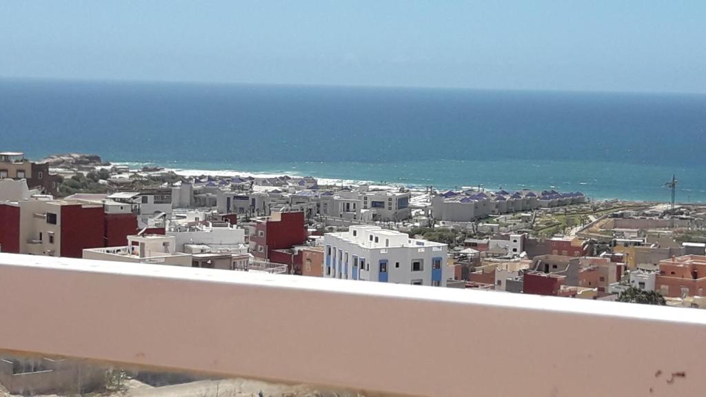 uitzicht op een stad met de oceaan en gebouwen bij Chambre Surf Oubaha Tamrakht Taghazout in Agadir