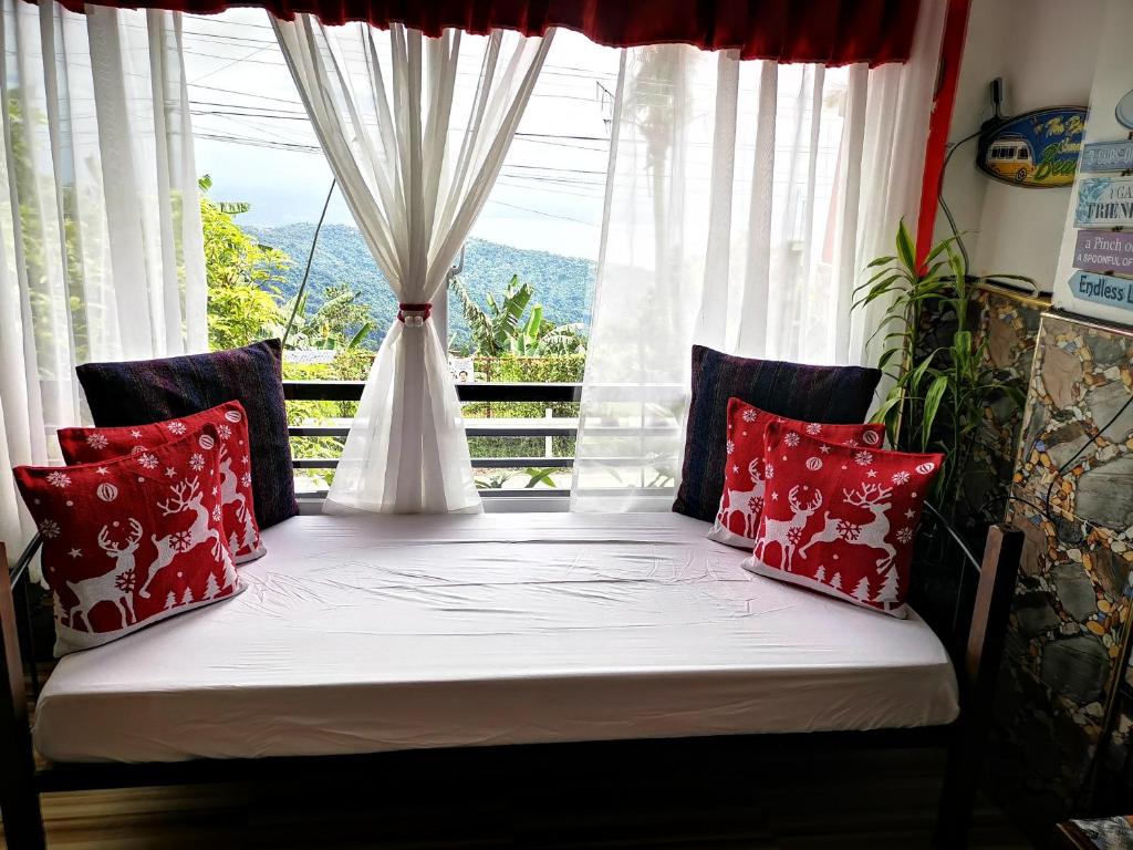 a bed in a room with a window at Country Bug Inn in Tagaytay