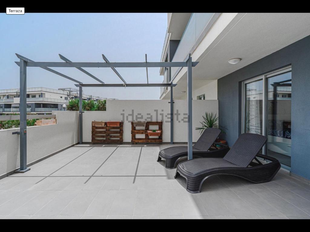 a patio with two chairs on a balcony at Sunbeach Apartment La Tejita in Granadilla de Abona