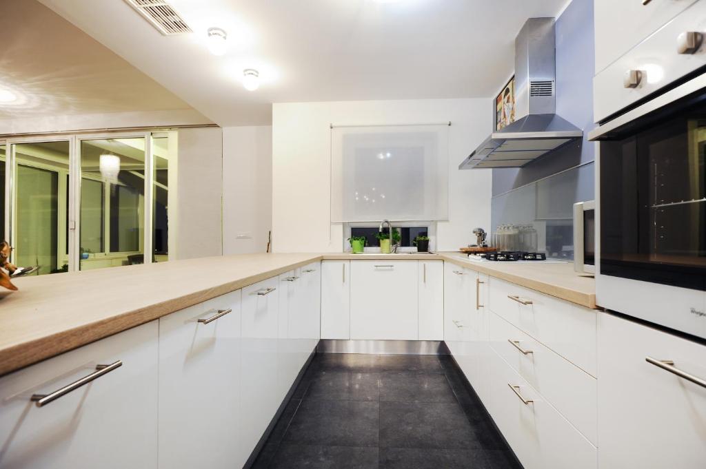 a kitchen with white cabinets and a black appliance at Penthouse Apartment in Zadar