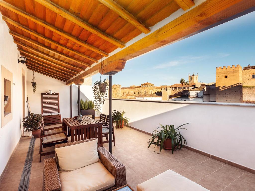 a balcony with furniture and a view of the city at Apartamentos Plaza Mayor 35 in Cáceres