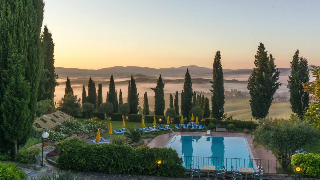 vista su un resort con piscina e alberi di Casanova - Panoramic Rooms and Suites a San Quirico dʼOrcia