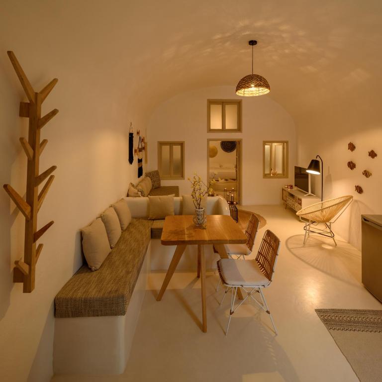 a living room with a couch and a table at Suite Home Santorini in Fira