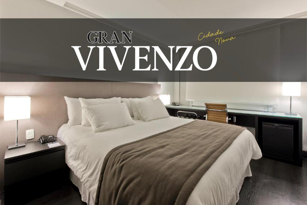 a bedroom with a large bed with a sign on the wall at Hotel Gran Vivenzo Belo Horizonte in Belo Horizonte