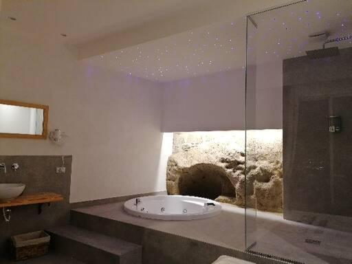 uma casa de banho com uma banheira e um chuveiro em vidro. em Lavinum em Monte di Procida