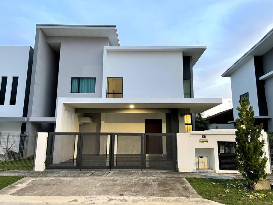 una gran casa blanca con entrada en Five BEDROOMS RESIDENTIAL HOME WITH FREE WIFI en Sepang