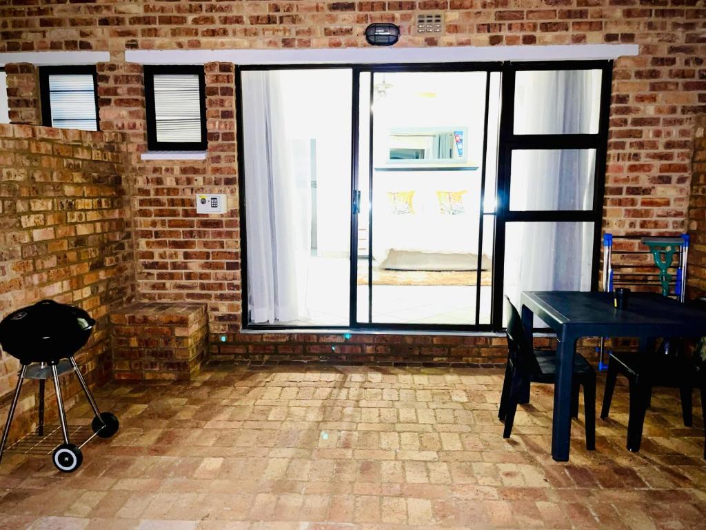 a dining room with a table and a large window at C&C HOTEL VIBES Randpark Ridge JHB 14 Units Available in Boskruin