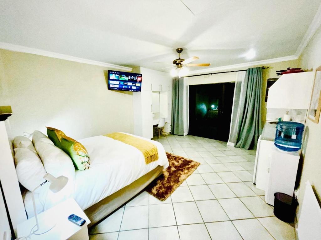 a bedroom with a bed and a tv on the wall at C&C HOTEL VIBES Randpark Ridge JHB 14 Units Available in Boskruin