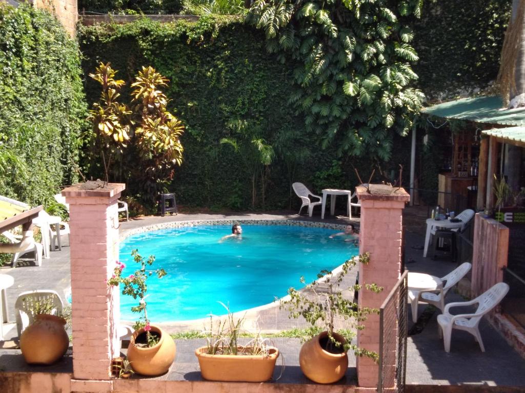 una piscina con una persona nadando en ella en Sweet Guest House en Puerto Iguazú